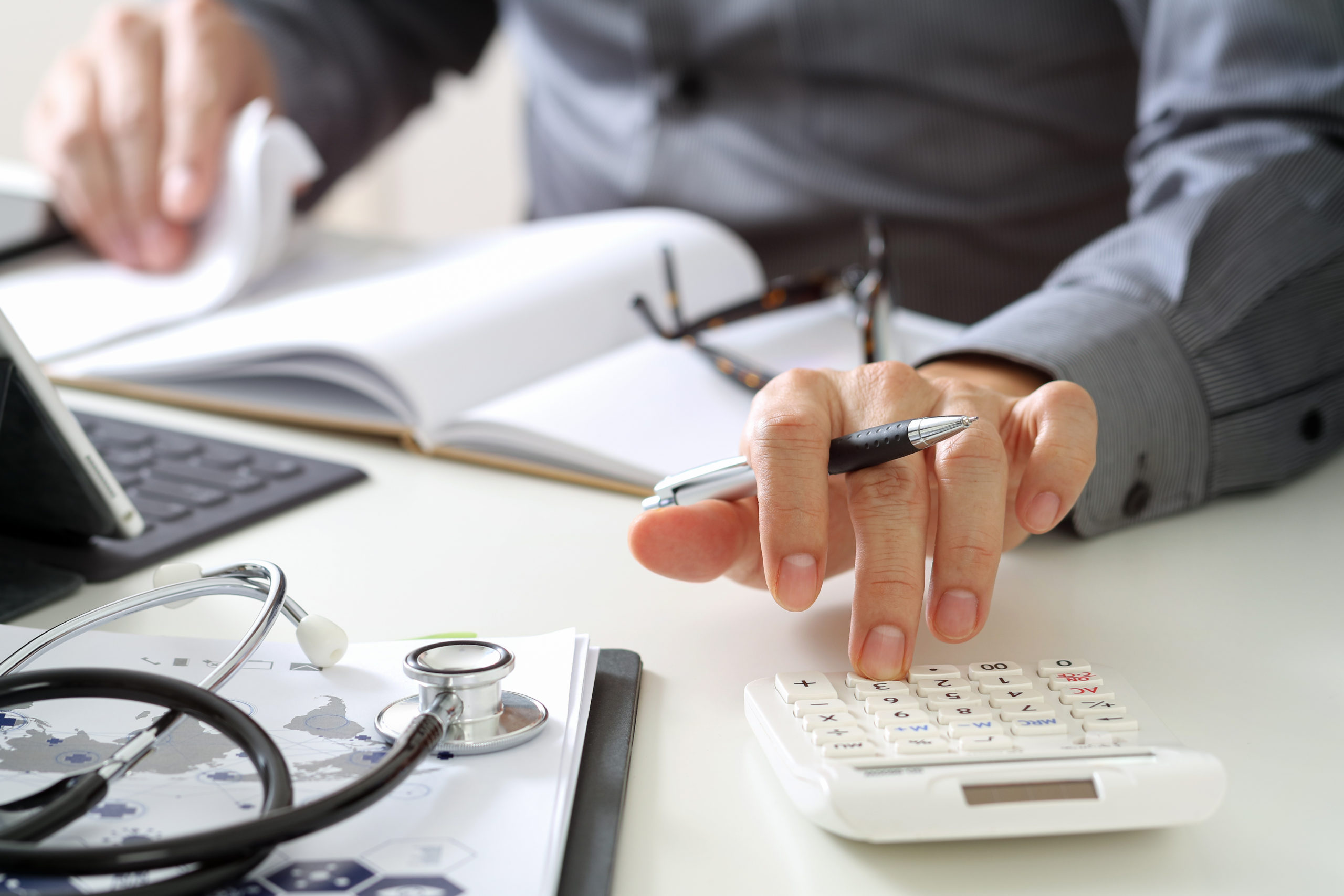 Person making calculations at their desk with their calculator